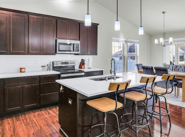 kitchen featuring a sink, plenty of natural light, appliances with stainless steel finishes, and dark wood-style floors