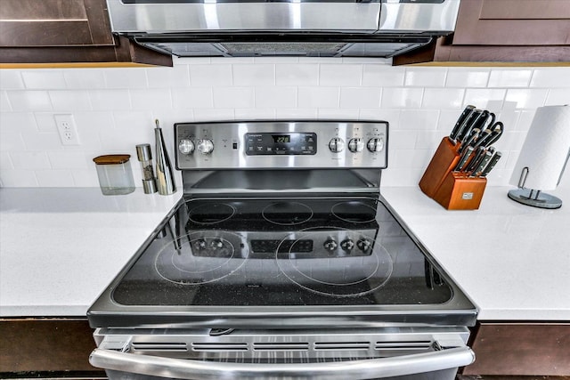 details featuring tasteful backsplash, stainless steel electric stove, dark brown cabinetry, and light countertops