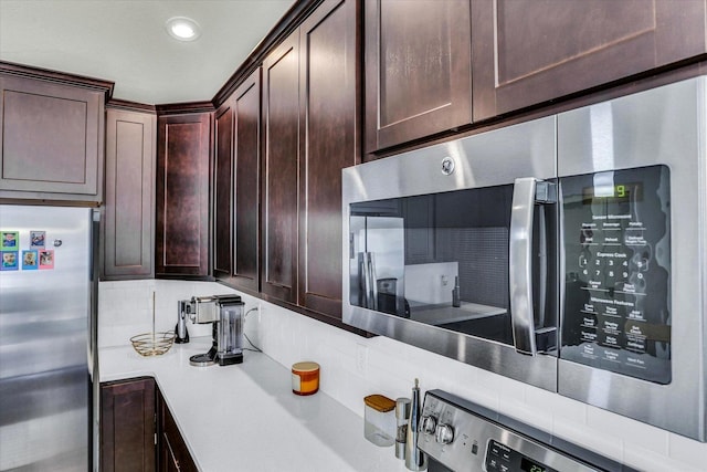 kitchen with dark brown cabinetry, appliances with stainless steel finishes, tasteful backsplash, and light countertops