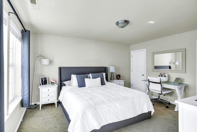 bedroom with baseboards, visible vents, and light carpet