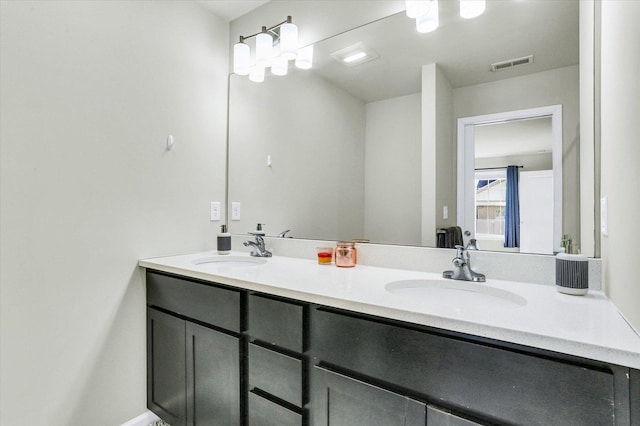 bathroom with double vanity, visible vents, and a sink