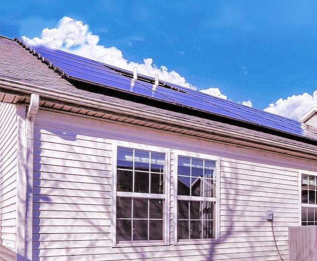 view of home's exterior with roof mounted solar panels