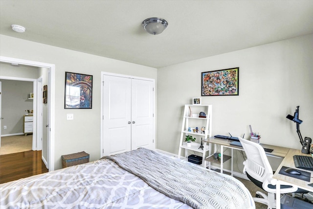 bedroom with a closet, baseboards, and wood finished floors