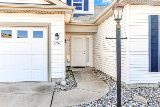 view of exterior entry with a garage and roof with shingles