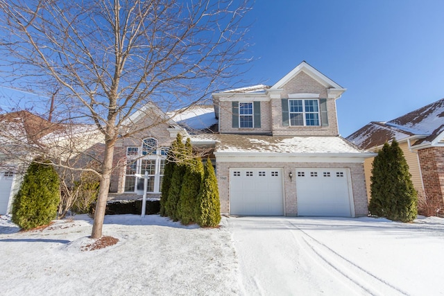 traditional home featuring brick siding, an attached garage, and driveway