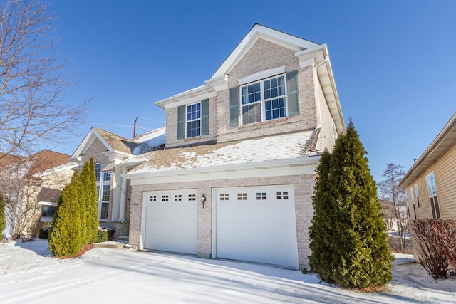 traditional-style home with a garage, brick siding, and roof with shingles