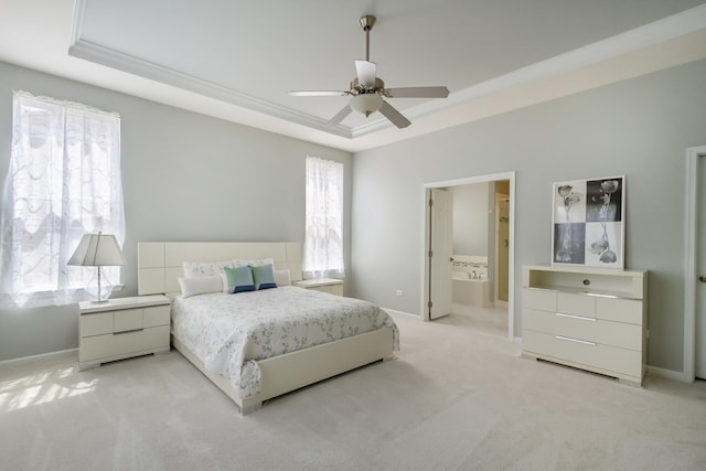 bedroom with a raised ceiling, multiple windows, and light colored carpet