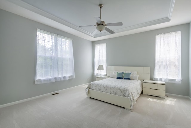 bedroom featuring baseboards, a raised ceiling, light carpet, and ceiling fan