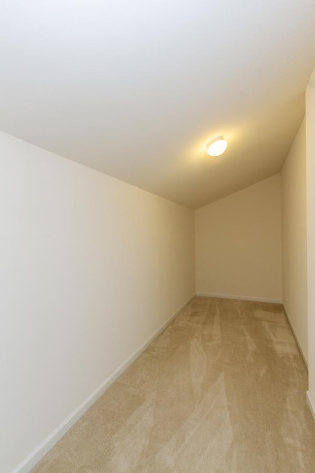 unfurnished room featuring baseboards and light carpet