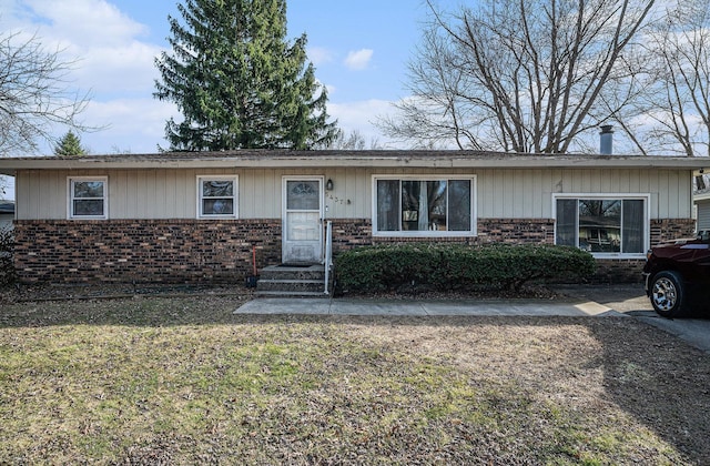 view of front facade with brick siding and a front yard