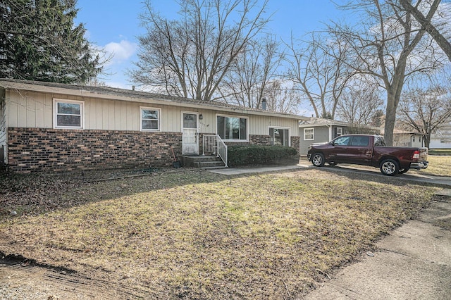 single story home featuring a front yard and brick siding