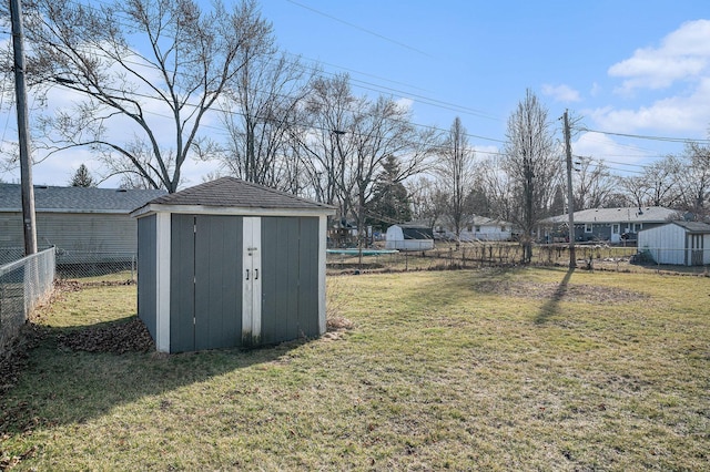 view of yard featuring an outbuilding, a storage shed, a trampoline, and a fenced backyard