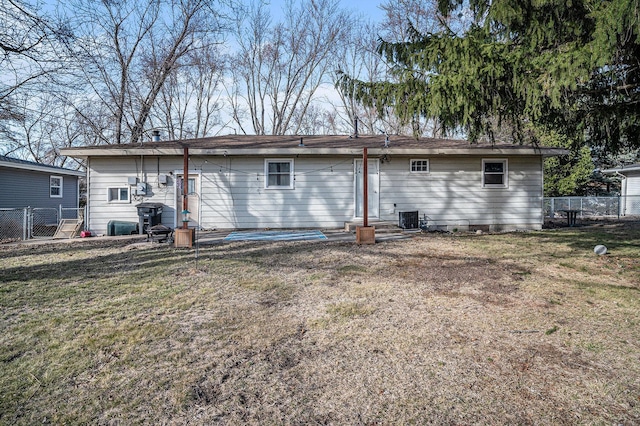 back of property featuring entry steps, a yard, central AC unit, and fence