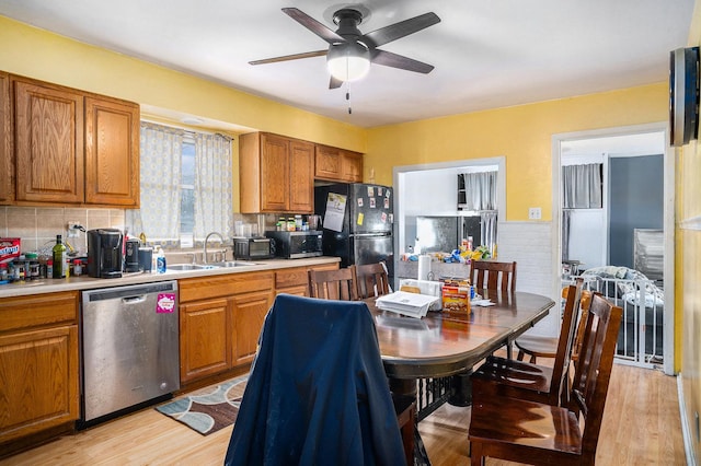 kitchen featuring brown cabinets, appliances with stainless steel finishes, light countertops, and a sink