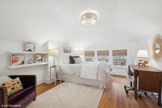 bedroom featuring crown molding, wood finished floors, and baseboards