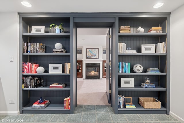 interior space featuring a fireplace with flush hearth, recessed lighting, and built in features