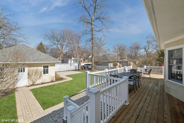 deck with outdoor dining area, a lawn, and a fenced backyard