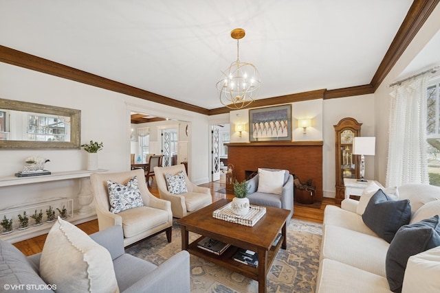 living area featuring a healthy amount of sunlight, wood finished floors, and ornamental molding