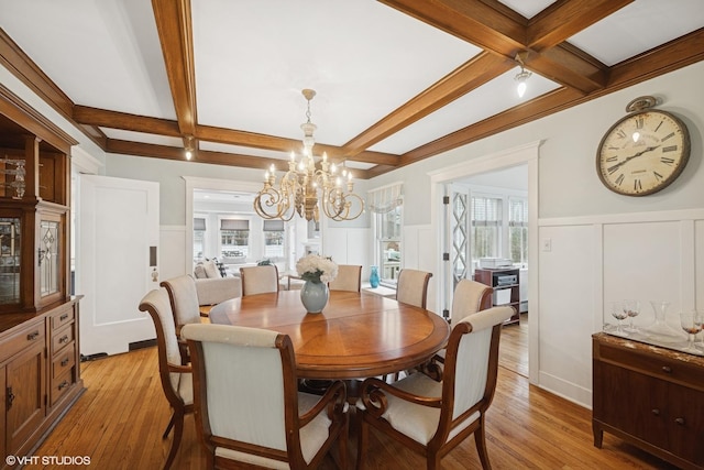 dining space featuring beam ceiling, light wood-style floors, and coffered ceiling