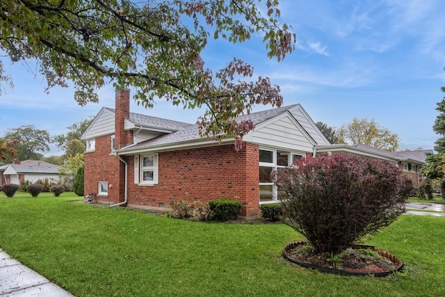 view of home's exterior featuring brick siding, a chimney, a lawn, and a shingled roof