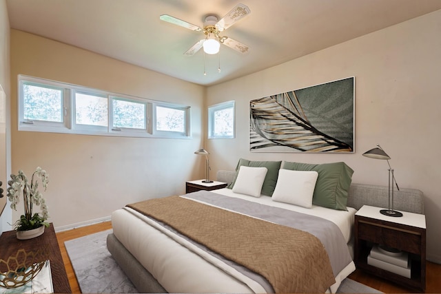 bedroom with baseboards, ceiling fan, and wood finished floors