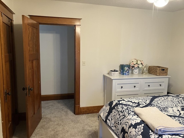 bedroom with light colored carpet and baseboards