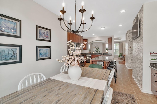 dining area featuring recessed lighting, an inviting chandelier, light tile patterned floors, baseboards, and arched walkways