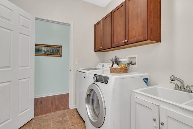 washroom with independent washer and dryer, light tile patterned floors, baseboards, a sink, and cabinet space