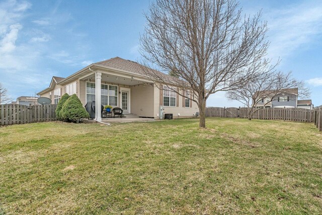rear view of house featuring a fenced backyard, a yard, and a patio area