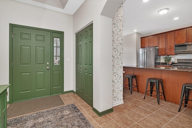 foyer entrance featuring baseboards, recessed lighting, and light tile patterned floors