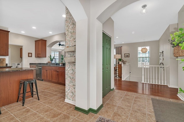 kitchen with arched walkways, a kitchen bar, recessed lighting, and dishwasher