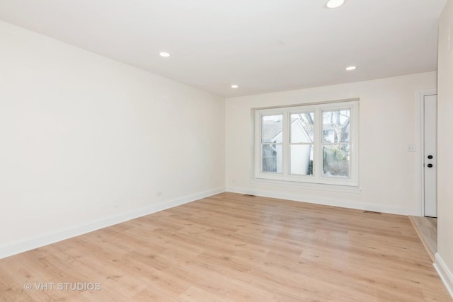 empty room featuring recessed lighting, baseboards, and light wood-style flooring