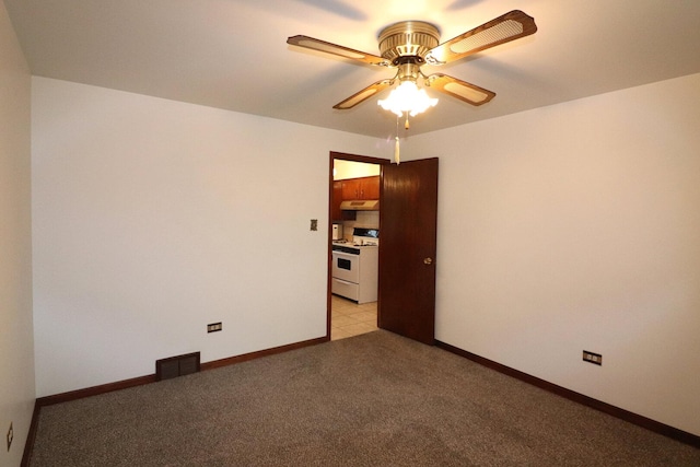 spare room featuring light carpet, visible vents, baseboards, and ceiling fan