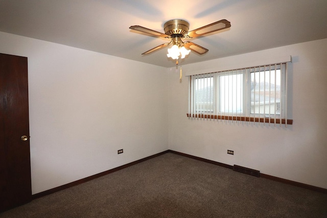 spare room featuring a ceiling fan, visible vents, baseboards, and dark colored carpet