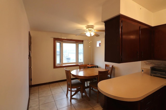 dining area with baseboards, ceiling fan, light tile patterned flooring, and a toaster