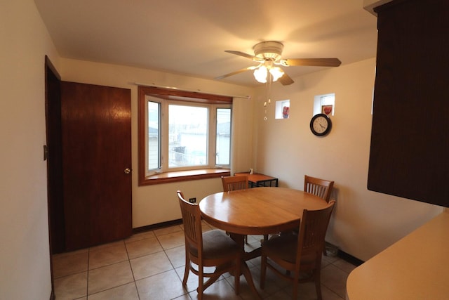 dining area featuring light tile patterned floors, baseboards, and ceiling fan