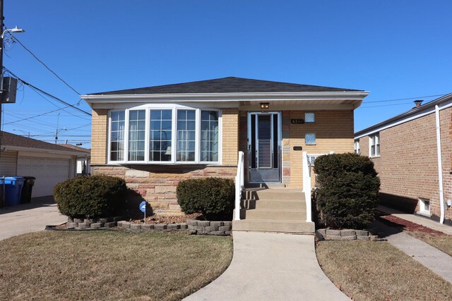 view of front of home featuring an outbuilding, brick siding, and roof with shingles