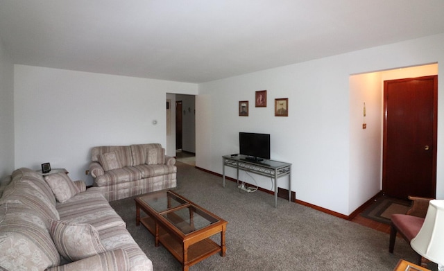 carpeted living area featuring baseboards