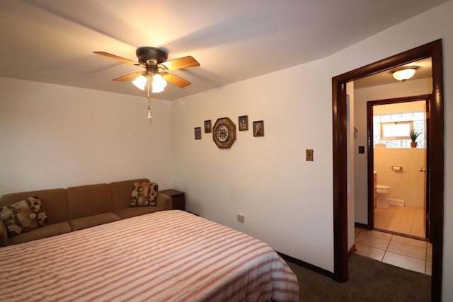 bedroom with light tile patterned flooring, light carpet, ensuite bathroom, and a ceiling fan