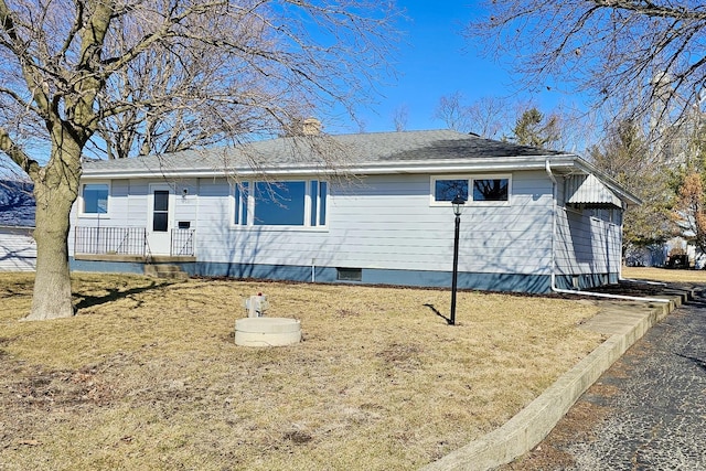 view of side of home with a shingled roof, a lawn, and a chimney