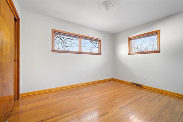 spare room featuring visible vents, baseboards, and light wood-style floors