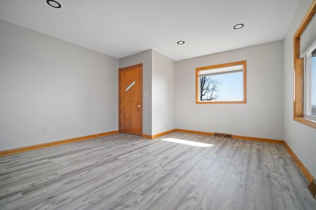 spare room with recessed lighting, visible vents, baseboards, and wood finished floors