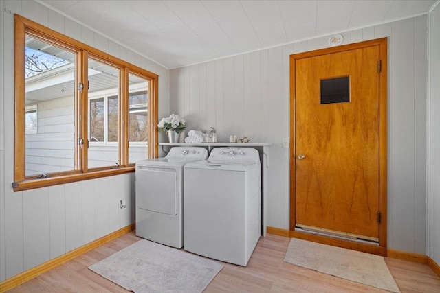 clothes washing area featuring light wood finished floors, laundry area, and separate washer and dryer