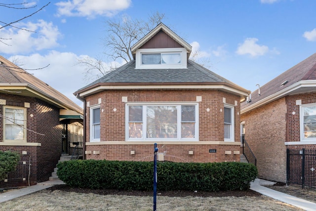 bungalow-style house featuring brick siding and a shingled roof