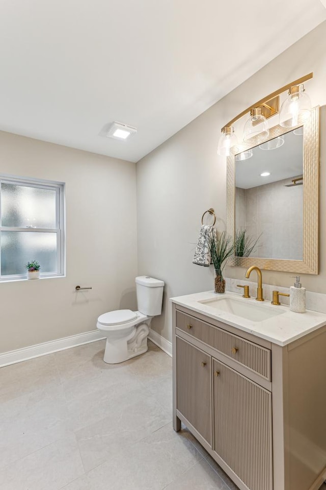 bathroom with vanity, toilet, and baseboards