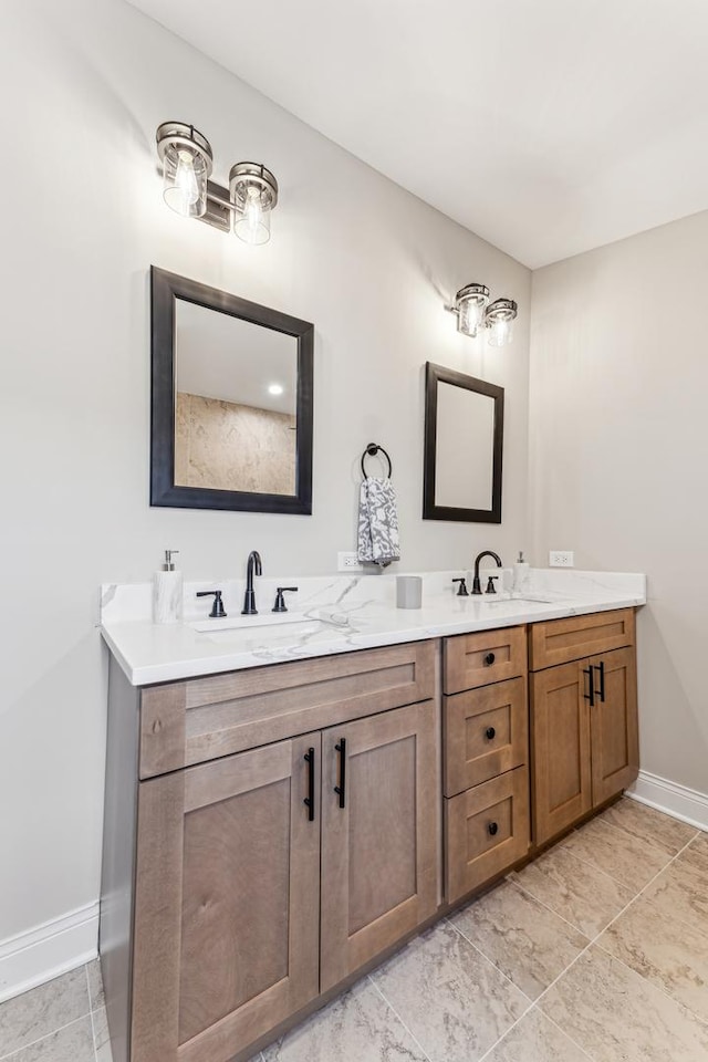 bathroom featuring double vanity, baseboards, and a sink