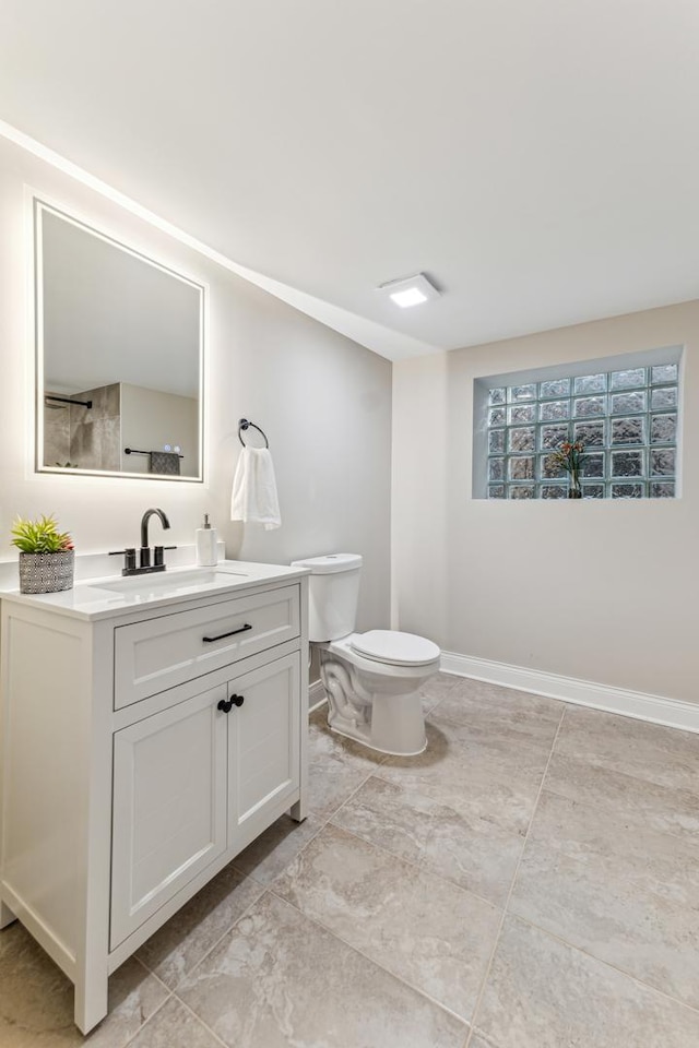 bathroom featuring baseboards, toilet, and vanity