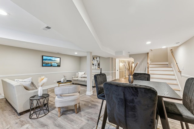 living area with recessed lighting, visible vents, wood finished floors, and stairs