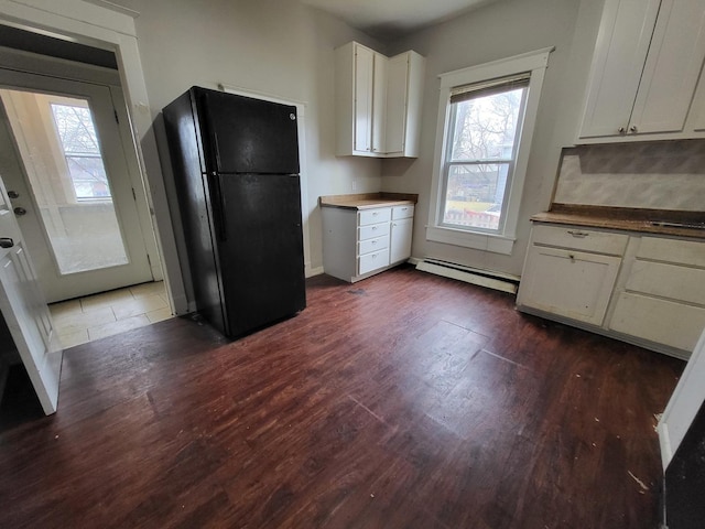 kitchen featuring a baseboard radiator, dark wood-type flooring, white cabinets, and freestanding refrigerator