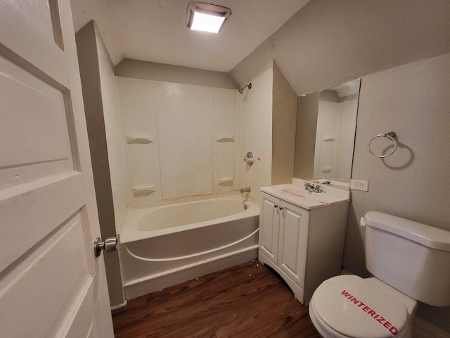 full bath with toilet, wood finished floors, bathtub / shower combination, vanity, and a textured wall